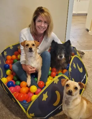 Stefanie Strackbein, owner of What Dogs Want and her dogs in a ball pit.