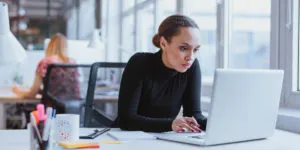 Young business executive using laptop