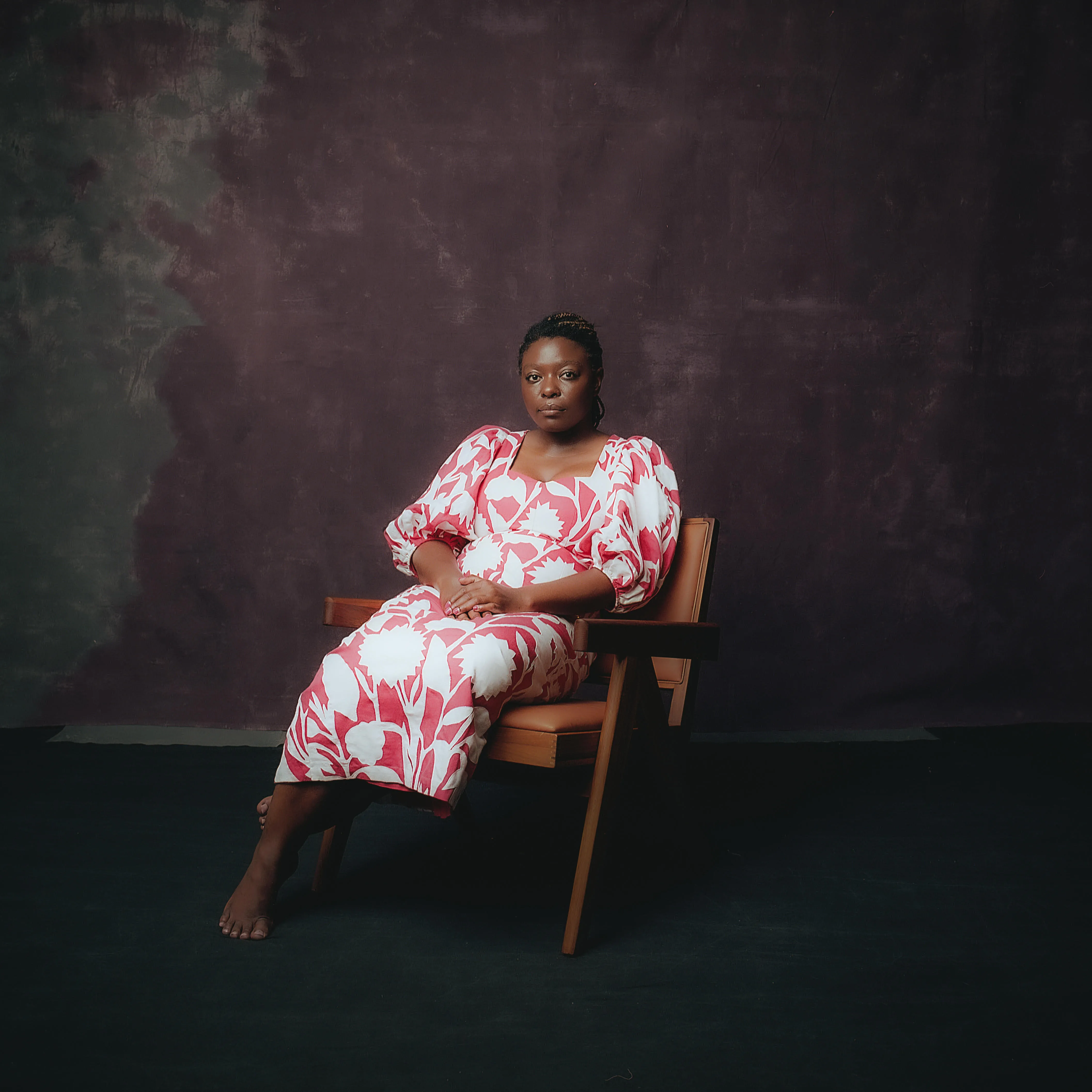 Black Woman sitting in a chair wearing a dress